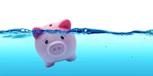 Piggy bank drowning in debt concept